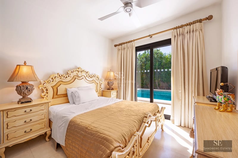 Spacious living room with fireplace, large windows, balcony with view. Modern design, wood floors, and natural light.