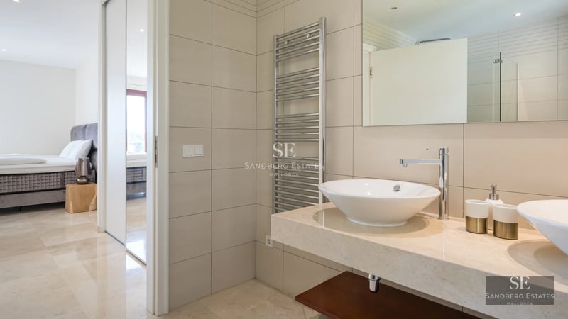 Exterior view of a modern villa with a pool, lush garden, and contemporary architectural design.