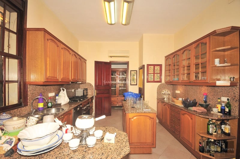 Spacious living room with sea view through panoramic windows. Modern design, light wood floors, white sofas and minimalist decor. Abundant natural light.
