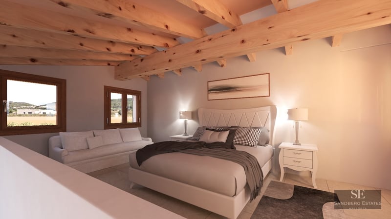 Bedroom with large bed, exposed wooden ceiling beams, white sofa, and windows looking out to the countryside.