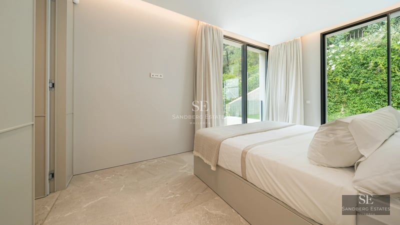 Spacious living room with fireplace and large windows. Designer sofas, soft rug, and panoramic views.