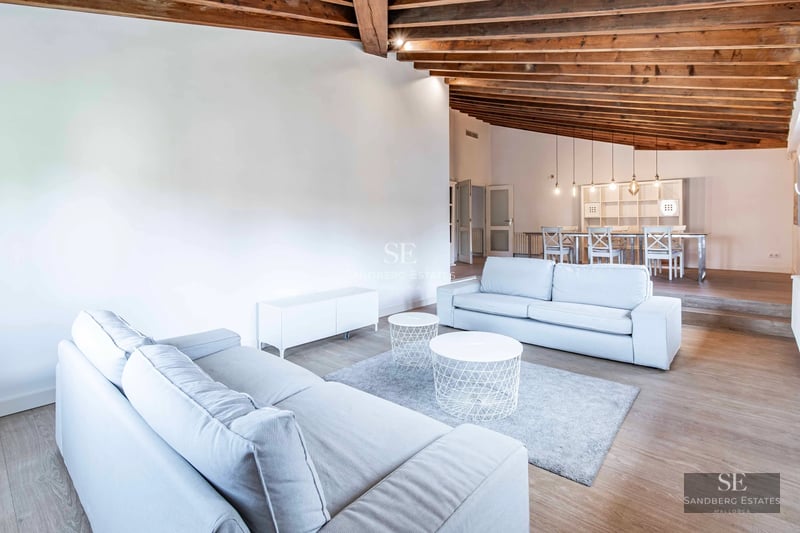 Wide view of modern villa with infinity pool. Minimalist design, large windows, and lush vegetation.