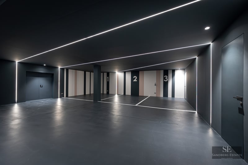 Luxury indoor parking with charcoal walls, numbered spaces 1-3, and linear LED strip lighting on ceiling and walls.