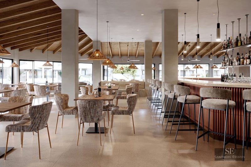 Modern bar with wooden beamed ceiling, wicker pendant lights, and upholstered bar stools.