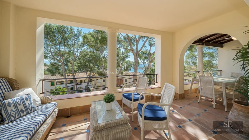 View of a luxurious villa with infinity pool. Modern architecture, large windows, turquoise pool, and lush gardens.