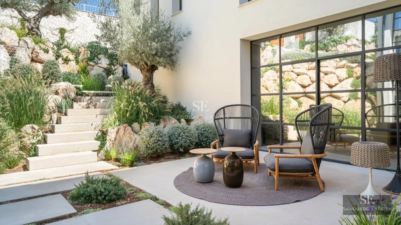 Spacious balcony with sea view, modern design, glass railing, and elegant outdoor furniture.