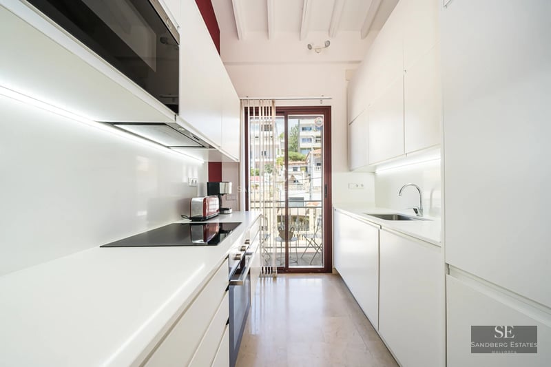 Exterior view of a modern house with an infinity pool, lush garden, and minimalist natural stone facade. Warm lighting.