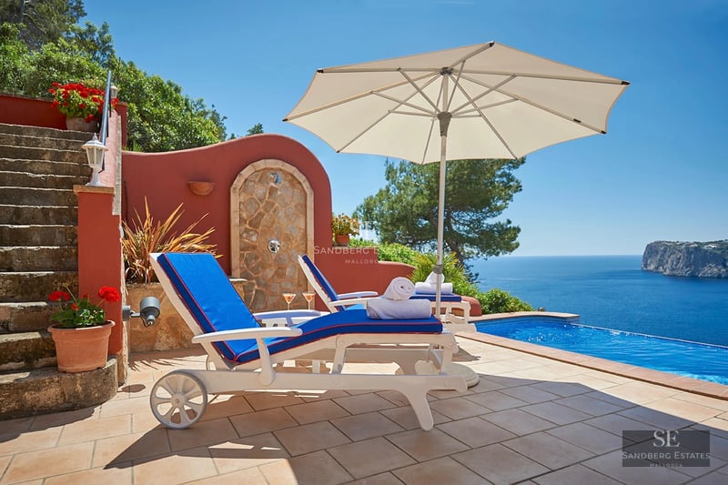 Exterior of a modern house with a swimming pool, lush garden, and terrace. Sleek architectural design with large windows.