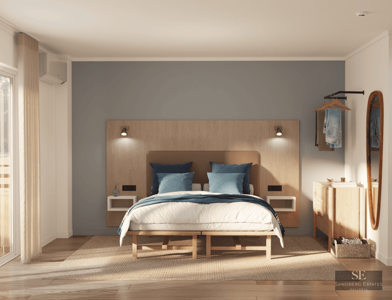 Bright master bedroom with a wooden headboard, blue accent wall, natural wood floors, and soft natural lighting.