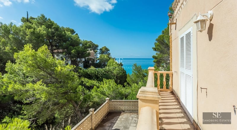 Exterior view of a modern house with a pool, well-kept garden, and large windows. Minimalist and elegant architecture.