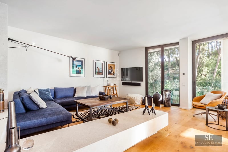 Exterior view of a modern villa featuring an infinity pool, lush garden, and expansive terraces. Minimalist architecture with large windows.