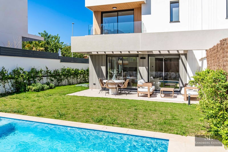 View of a luxurious villa with a pool and lush garden. Modern architecture featuring large windows and high-quality materials.
