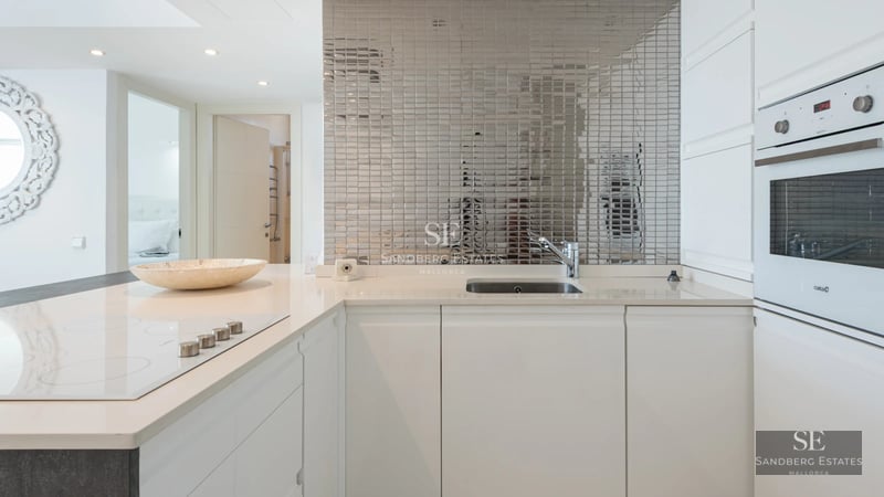Spacious living room with panoramic windows, light wood flooring, minimalist design furniture, and garden views. Natural lighting.
