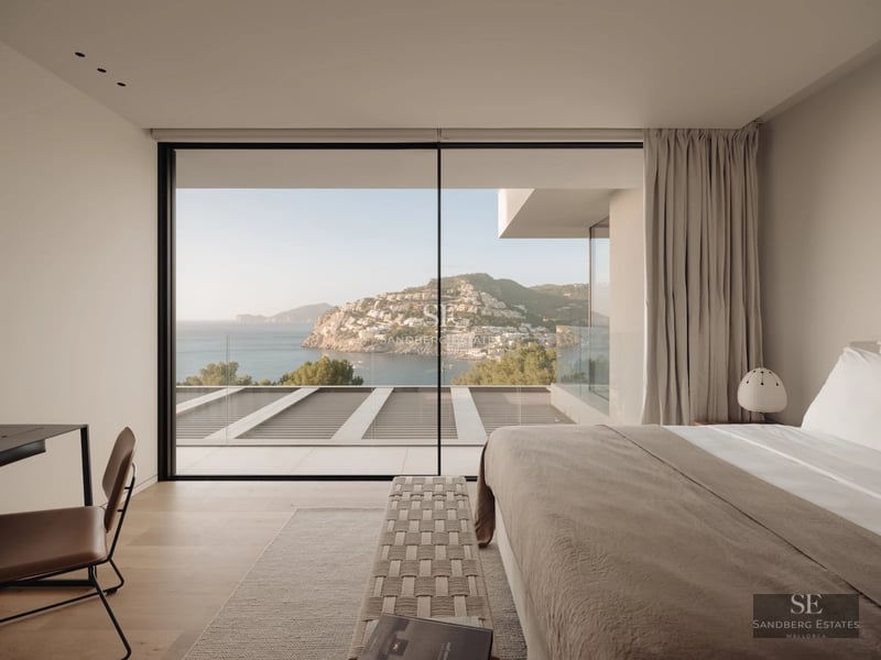 Spacious living room with panoramic sea views. Modern design, light wood floors, and minimalist furniture in neutral tones.