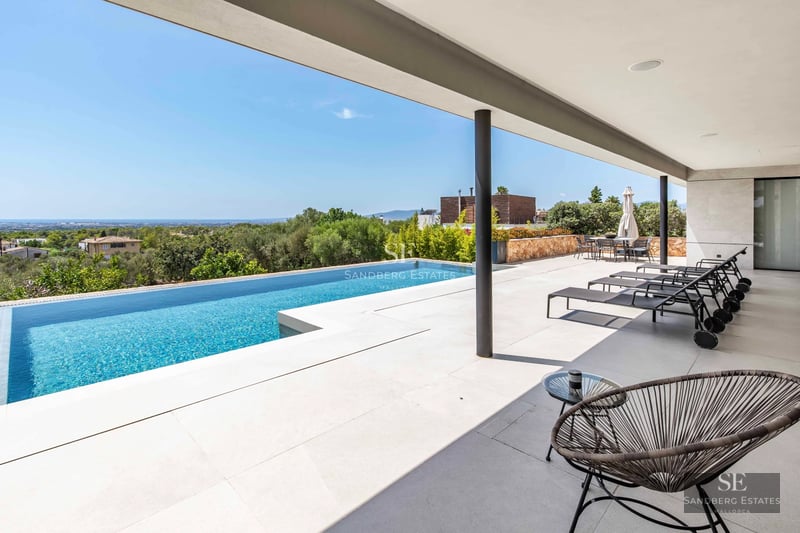 Exterior of modern villa with infinity pool, lush garden, and minimalist architecture. Warm sunset lighting.