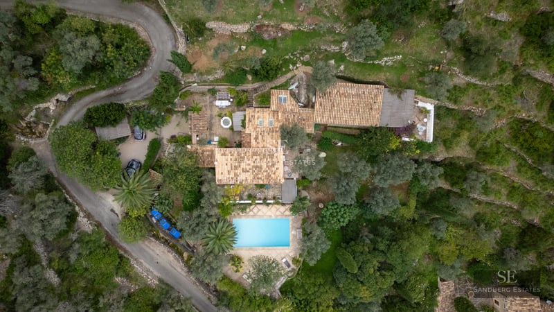 View of a luxurious property featuring a pool, landscaped garden, and modern architecture. High-quality design details.