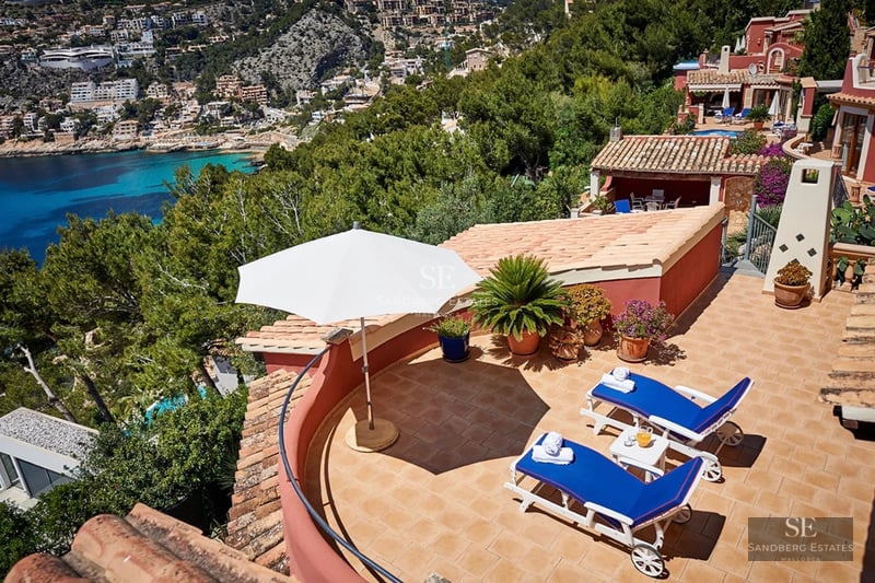 Exterior of a modern villa with infinity pool, spacious terraces and sea views. Minimalist and elegant architectural design.