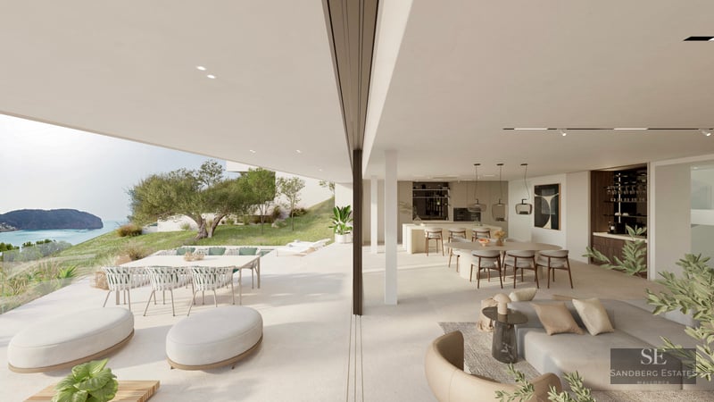 Bright, open-plan living and dining room merging with a spacious terrace overlooking the sea and coastline.