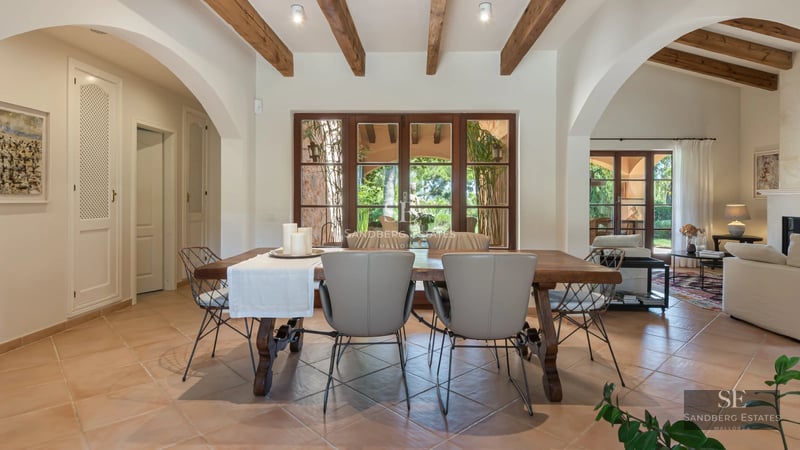 Exterior view of a modern villa with pool, large windows, minimalist design, and lush vegetation.