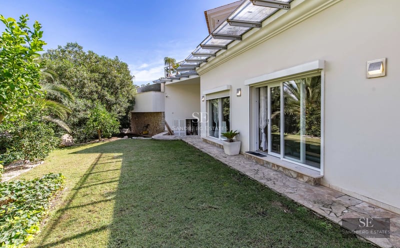 Pool view with sun deck and modern furniture. Minimalist facade with large windows reflecting sunlight.
