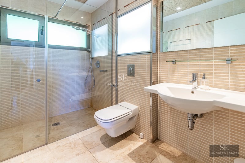 Exterior of modern villa with pool. Minimalist design, large windows, manicured landscaping. Light reflecting on the water.