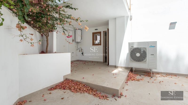 Spacious living room with fireplace, large windows, and terrace access with views. Elegant furniture and modern decor.