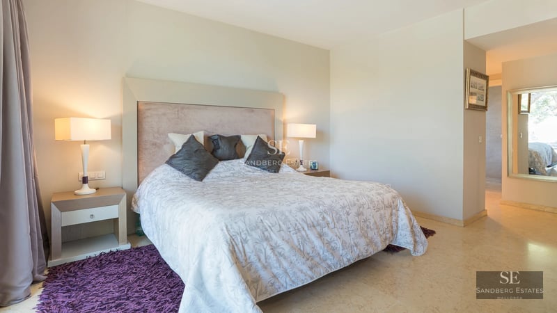 Exterior view of a luxurious, modern home featuring an infinity pool, garden, and expansive terraces. Minimalist design and high-end finishes.