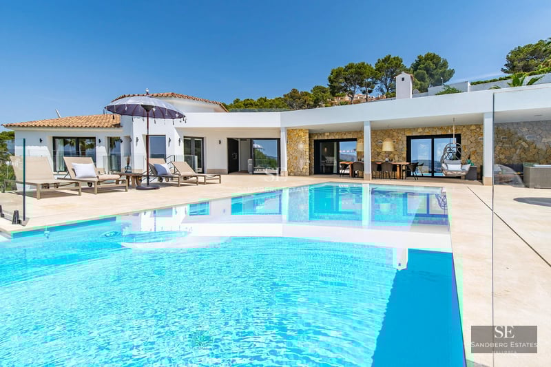 Bright living room with large windows, light wood floors and modern furniture. Panoramic sea views.