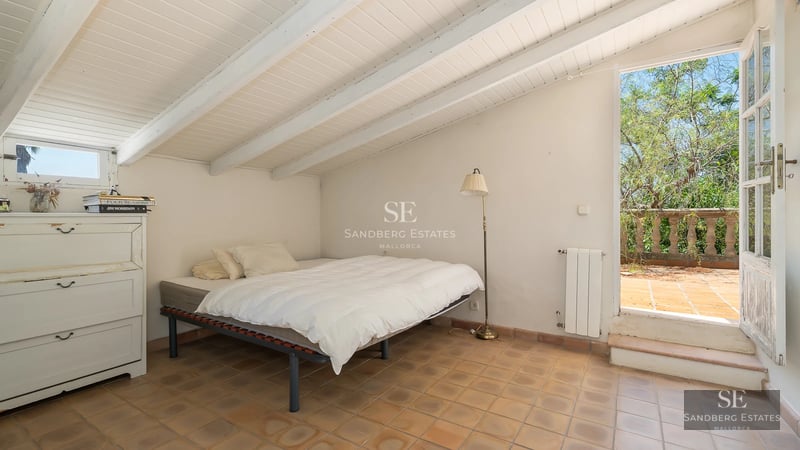 Spacious living room with large windows, light wood floors, modern sofas, and panoramic sea views. Natural lighting and minimalist decor.