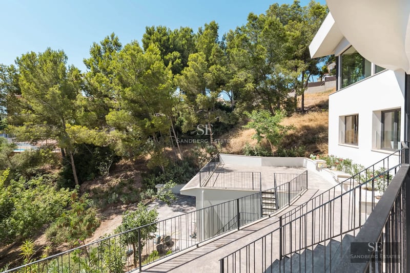 Exterior view of a modern villa with an infinity pool. Minimalist architecture, large windows and elegant landscaping.