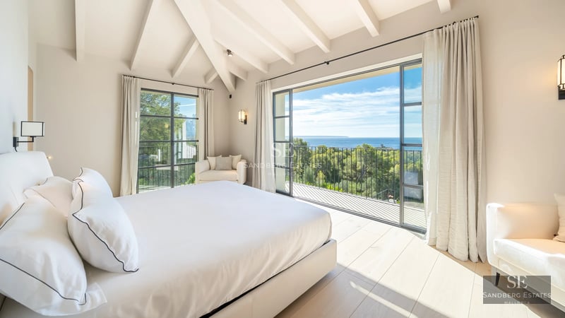 View of villa with reflecting pool, manicured garden, and modern architecture featuring large windows. Luxurious and serene ambiance.