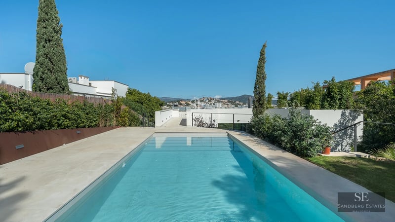 Modern villa featuring an infinity pool, large windows, and minimalist architecture. Warm lighting and designer furniture.
