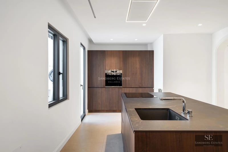Exterior view of a modern villa featuring an infinity pool, lush garden, and natural stone facade. Large windows and minimalist design.