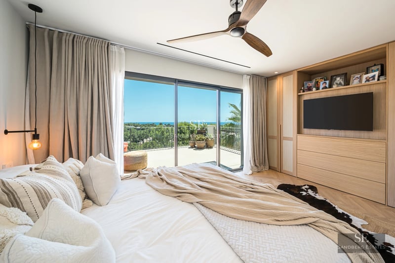 Vue extérieure d'une maison moderne avec piscine, jardin luxuriant et large baie vitrée illuminant l'intérieur. Design élégant et contemporain.