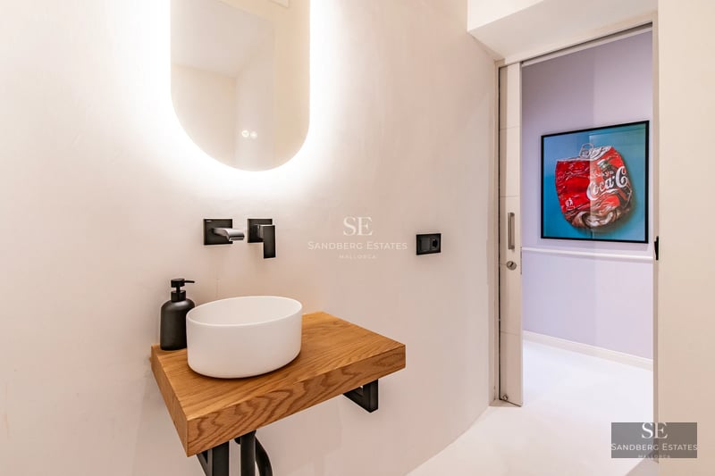 Spacious living room with floor-to-ceiling windows overlooking the sea. Modern interior with stylish furniture and natural light. Beige sofa, light rug.