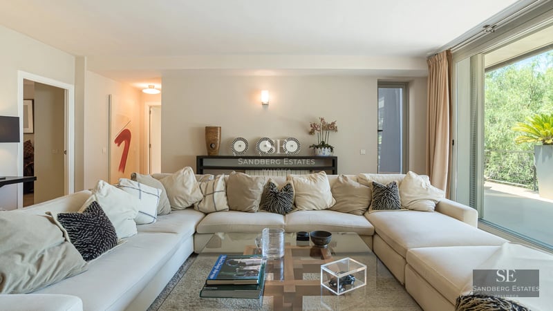 Exterior view of modern villa with infinity pool. Minimalist architecture, large windows, and lush vegetation.