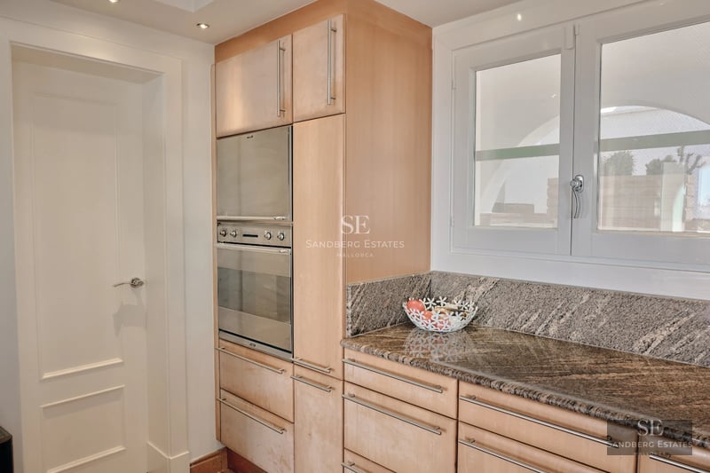 Spacious balcony with sea view. Modern design featuring glass railings and comfortable outdoor furniture.