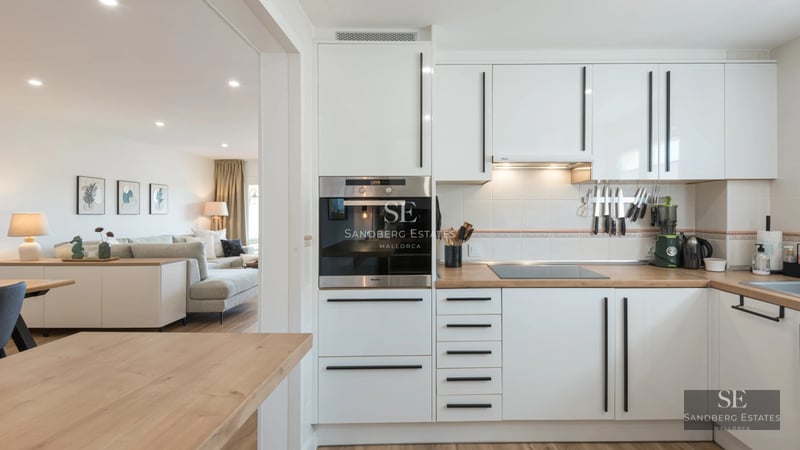 Spacious terrace with designer outdoor furniture, glass railing, and panoramic sea views. Soft lighting and wooden floor.