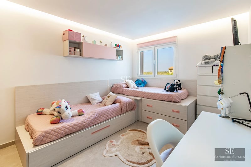 Spacious living room featuring large windows, a modern fireplace, light wood floors, and panoramic outdoor views. Designer sofas and minimalist decor.