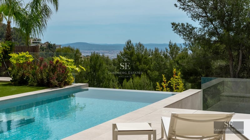 Spacious balcony with panoramic sea views. Modern design, glass railing, and stylish furniture. Warm lighting and wooden flooring.