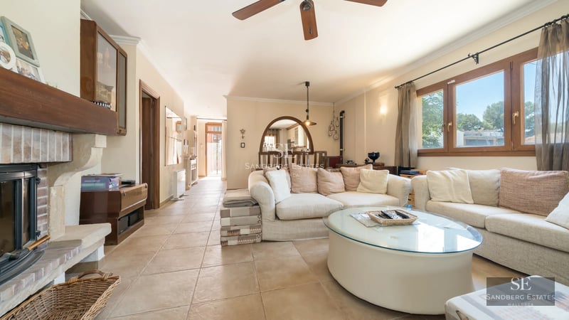 Spacious living room with balcony, light wood floors, white walls, large windows, and sea view. Natural lighting.