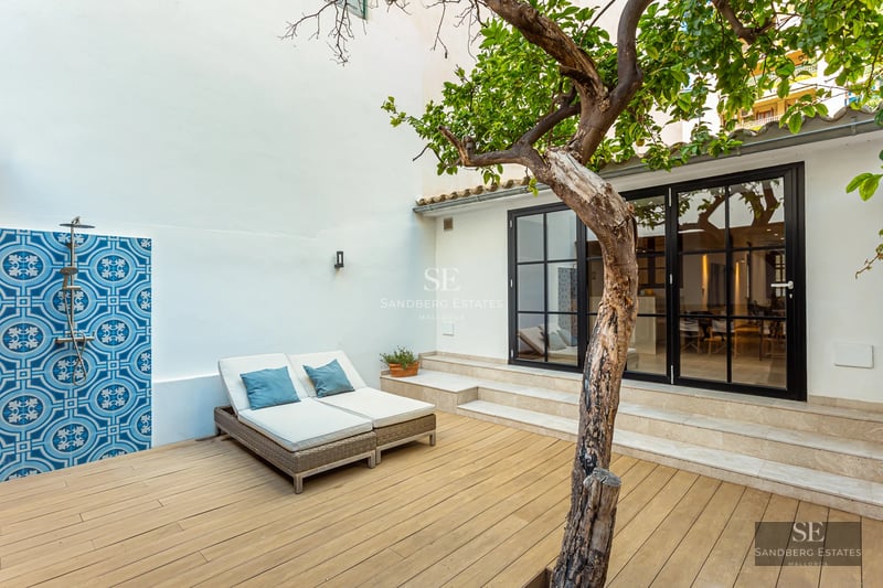 View of a modern pool surrounded by lush greenery with direct access to a luxurious residence. Minimalist design.