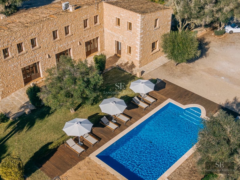 Panoramic view of a modern villa featuring a pool, lush garden, and minimalist architecture. Large windows and a sunny terrace.