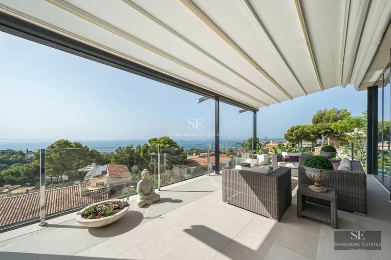Spacious living room with fireplace, floor-to-ceiling windows and garden view. Modern design, abundant natural light and high-quality finishes.