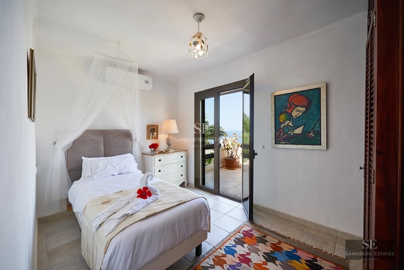 Bright living room with a modern fireplace and large windows offering panoramic ocean views. Minimalist and elegant decor.