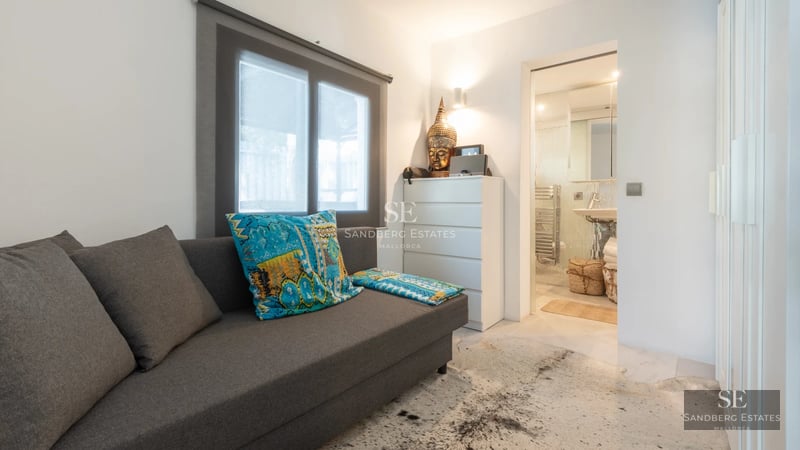 Spacious balcony with panoramic sea views. Glass railing, modern furniture, and minimalist design. Outdoor lamp fixture.