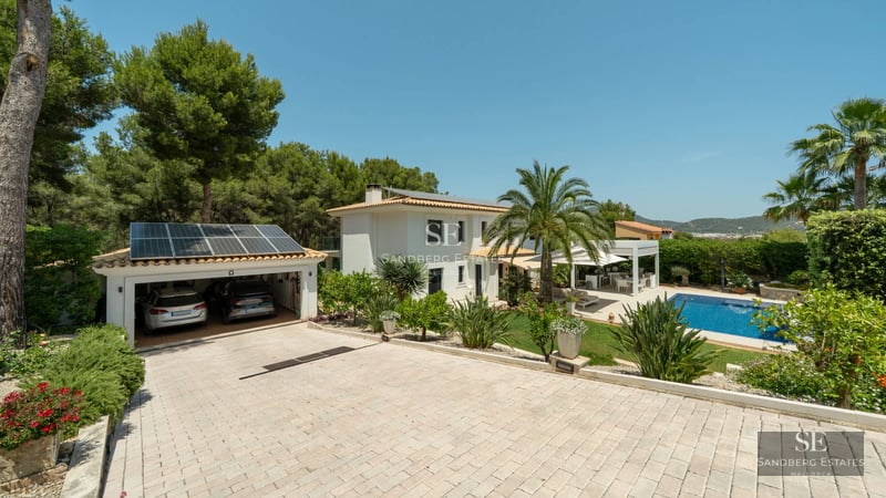 Modern apartment featuring a glass-enclosed balcony with panoramic sea views. Sleek, minimalist design with wood and stone accents.