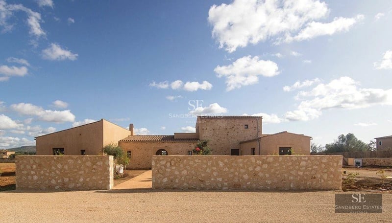 View of a modern villa featuring a pool, lush garden, and expansive windows offering natural light. Minimalist architecture.
