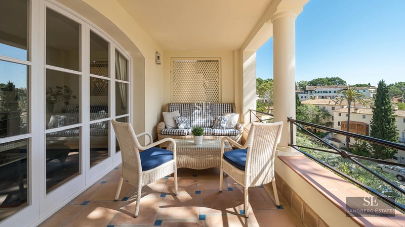 Exterior view of a modern villa featuring an infinity pool, surrounded by greenery, and boasting large windows.