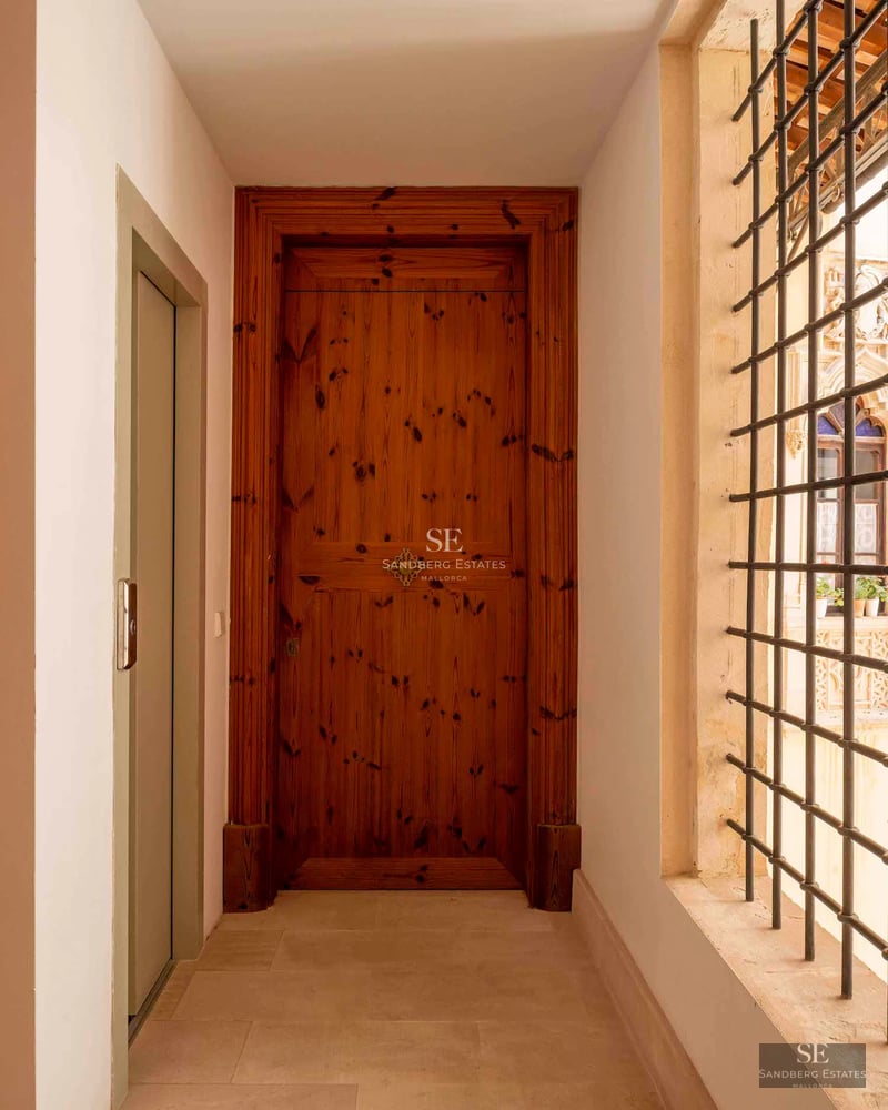 View of a modern infinity pool surrounded by greenery and a minimalist design house in the background.